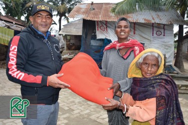 The senior individuals are receiving blankets from a staff of Rishilpi